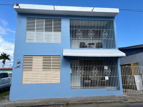 una casa azul con dos perros en sus jaulas en Santoni’s Luxury Rentals, en Cabo Rojo