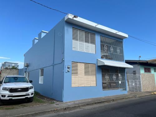 un edificio azul con un coche aparcado delante de él en Santoni’s Luxury Rentals, en Cabo Rojo