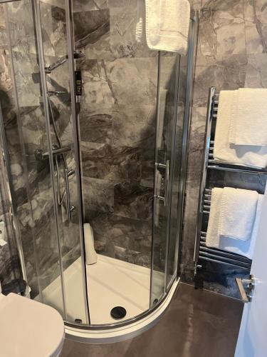 基爾肯尼的住宿－格蘭笛尼酒店，带淋浴、卫生间和毛巾的浴室