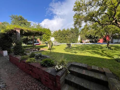 a garden with a stone wall and a bench and grass at Palacete da Real Companhia do Cacau - Royal Cocoa Palace in Montemor-o-Novo