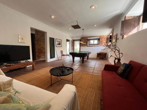 a living room with a couch and a pool table at Palacete da Real Companhia do Cacau - Royal Cocoa Palace in Montemor-o-Novo