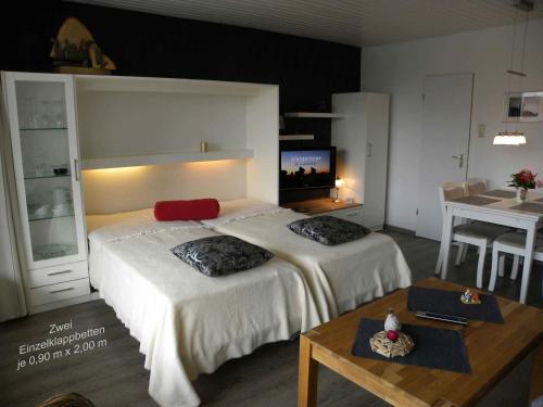 um quarto de hotel com duas camas e uma mesa em Ferienwohnung Little Poseidon em Wangerooge