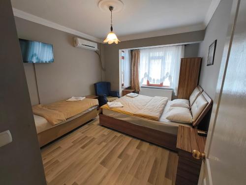 Habitación pequeña con 2 camas y ventana en Tac Pansiyon, en Edirne