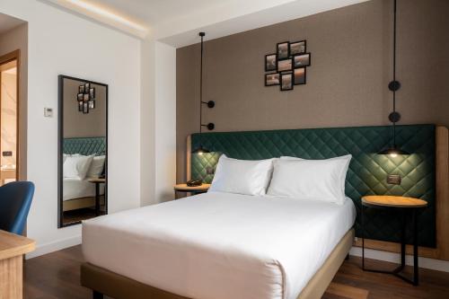 a bedroom with a large white bed and a mirror at Hilton Garden Inn Milan Malpensa in Somma Lombardo