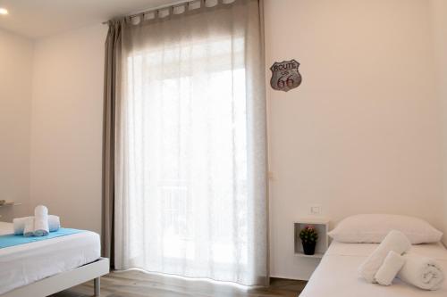 a bedroom with two beds and a large window at Il Giramondo in Agropoli