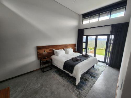 a bedroom with a bed and a large window at Bald Ibis (856 Highland Gate) in Dullstroom