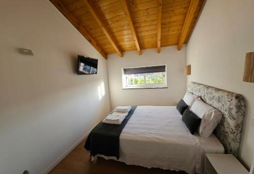 een kleine slaapkamer met een bed en een raam bij Casa do Chafariz - Rooms in Cercal