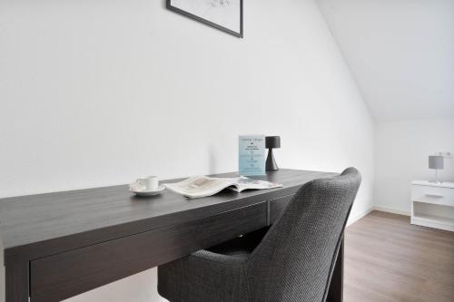 a wooden desk with a chair and a table and a table and chairsuggest at Schöne Apartments in Lengerich I home2share in Lengerich