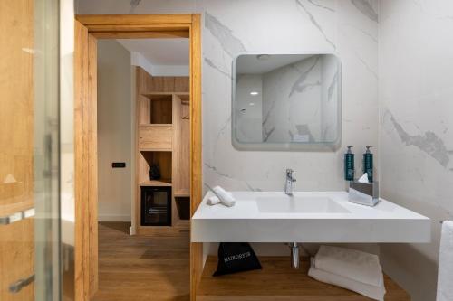 bagno con lavandino bianco e specchio di Hilton Garden Inn Milan Malpensa a Somma Lombardo
