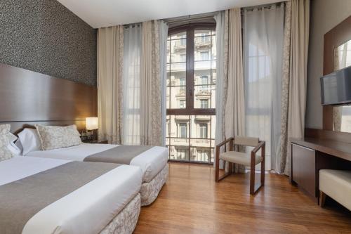 una camera d'albergo con letto e finestra di Barcelona Hotel Colonial a Barcellona