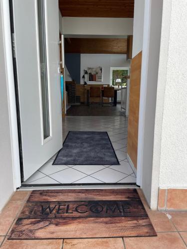 a door leading into a hallway with a welcome mat at Ferienhaus Chalet Andante in Hannoversch Münden