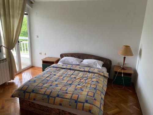 1 dormitorio con 1 cama con 2 mesitas de noche y una ventana en Guesthouse Vionica, en Međugorje