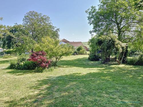a yard with trees and bushes and a house at Le Gite de Mamou, grande capacité proche de Strasbourg in Uhlwiller