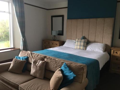 een slaapkamer met een groot bed en een bank bij Kestor Inn, Manaton, Dartmoor National Park, Newton Abbot, Devon in Manaton