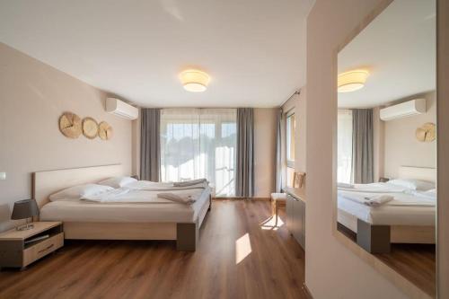 a bedroom with two beds and a large window at Moana Sunset Apartment in Ahtopol