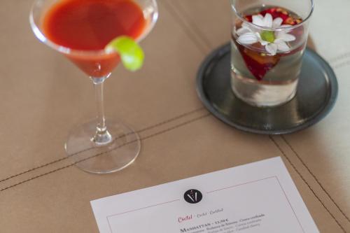 a drink on a table next to a plate with a cocktail at Barcelona Hotel Colonial in Barcelona