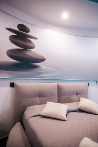 a couch in a room with a wall with a painting at B&BIO SPA in Catanzaro