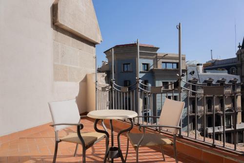 a balcony with a table and chairs on a building at Barcelona Hotel Colonial in Barcelona
