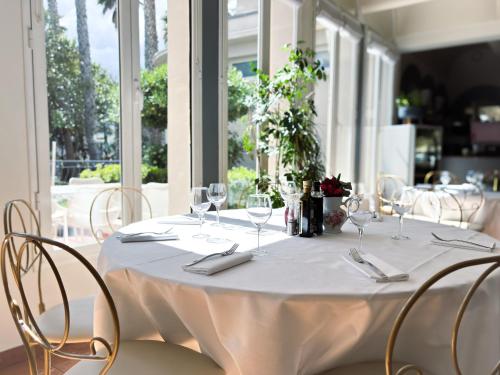 a table with chairs and a white table cloth at Ostella Spa & Resort in Bastia