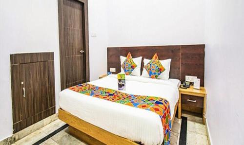 a bedroom with a large bed with a wooden headboard at FabHotel Golden Pettals in Gurgaon