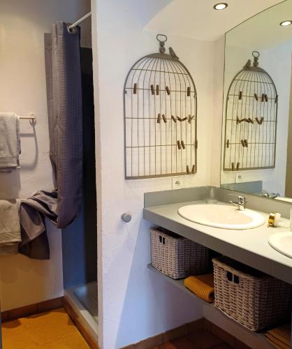 une salle de bain avec un lavabo et deux cages à oiseaux dans l'établissement Clos Baroanni - Studio La Volière, à Terraube