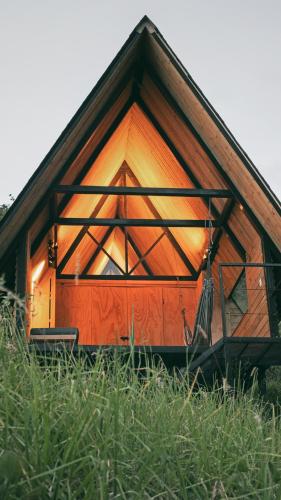 Cabaña pequeña con ventana grande en un campo de césped en Ecolodge Cuentos de Agua, en Villamaría