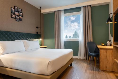 una camera d'albergo con letto e finestra di Hilton Garden Inn Milan Malpensa a Somma Lombardo