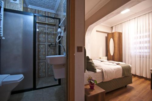 a bathroom with a bed and a sink and a toilet at Aurora Eco Hotel in Istanbul