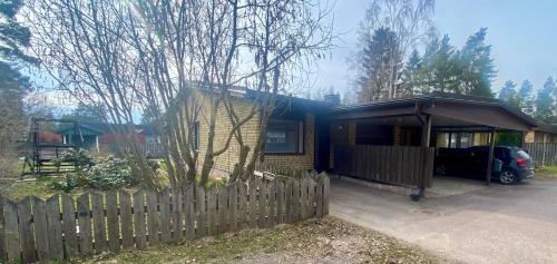 una pequeña casa con una valla delante de ella en Fully-equipped apt, Free parking, private backyard, en Kotka