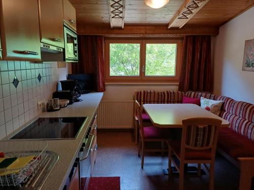 a kitchen and living room with a table and a couch at Landhaus Eberler in Mayrhofen