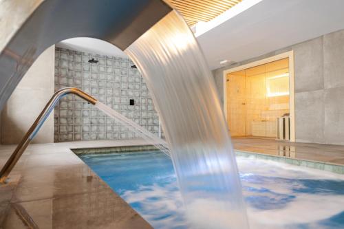 a swimming pool with a water fountain at Hotel & Spa Convento San Francisco in Soria