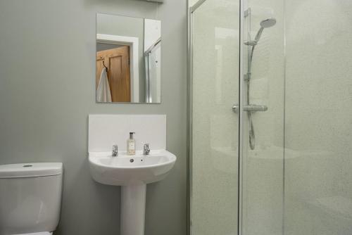 een badkamer met een wastafel en een glazen douche bij The Rushes in Bamburgh