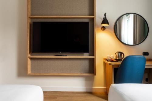 a living room with a flat screen tv on a wall at Hilton Garden Inn Milan Malpensa in Somma Lombardo