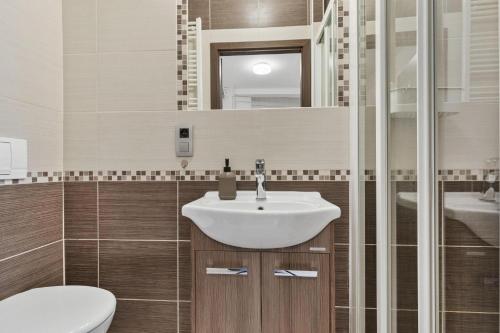 a bathroom with a sink and a toilet and a mirror at Apple apartment in Bratislava