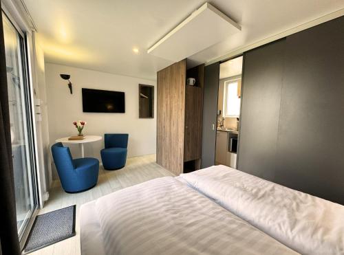 una camera con un letto e due sedie blu di Golf Cubes Hohwacht a Hohwacht