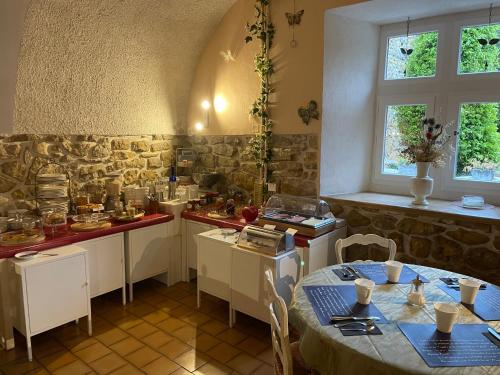 eine Küche mit einem Tisch und Stühlen im Zimmer in der Unterkunft Le Manoir du Raveyron in Vallon-Pont-dʼArc