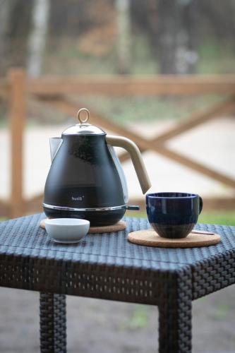 a tea kettle and a cup on a table at Na Skraju Lasu e-apart in Jastrzębia Góra