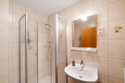 La salle de bains est pourvue d'un lavabo et d'une douche. dans l'établissement Strandferienwohnung, à Graal-Müritz