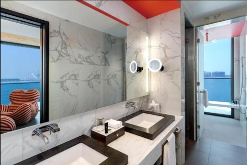 a bathroom with a sink and a large mirror at Hyatt Centric Jumeirah Dubai - Deluxe Room - UAE in Dubai