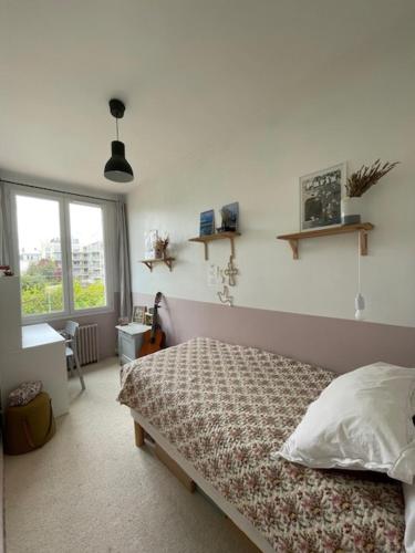 een slaapkamer met een bed in een kamer met een raam bij Maison idéalement située à Versailles in Versailles