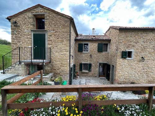 a stone house with a wooden fence in front of it at Monte Cuccolo House B&B in Fontanelice