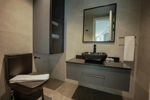 a bathroom with a sink and a toilet and a mirror at J 22 Residence in Lusail