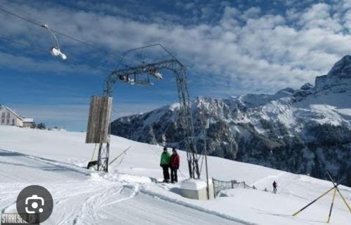 Alpenperle في Isenthal: شخصين واقفين على مصعد التزلج في الثلج