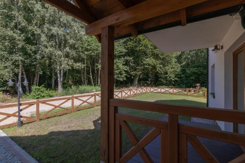 a view from the porch of a house with a fence at Na Skraju Lasu e-apart in Jastrzębia Góra