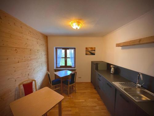 a kitchen with a table and a sink and a table and chairs at Ferienhaus Daxenberger in Bernau am Chiemsee