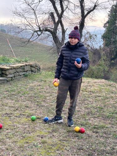a young boy standing in a field with balls at Monte Cuccolo House B&B in Fontanelice