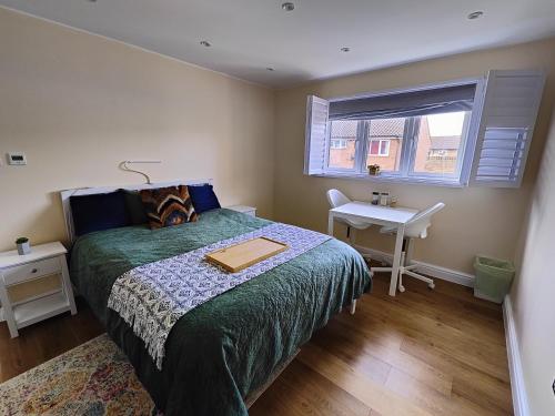 1 dormitorio con cama, escritorio y ventana en Clifton House en Londres