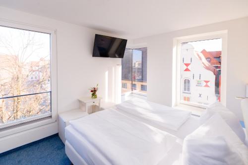ヴィスマールにあるホテル ニュー オリンズの白いベッドルーム(ベッド1台、窓付)