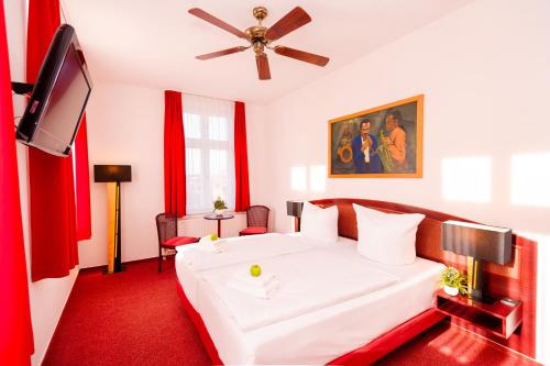 a bedroom with a white bed and a flat screen tv at Hotel New Orleans in Wismar