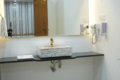 a bathroom counter with a sink and a mirror at Hotel Y Palace in Ongole